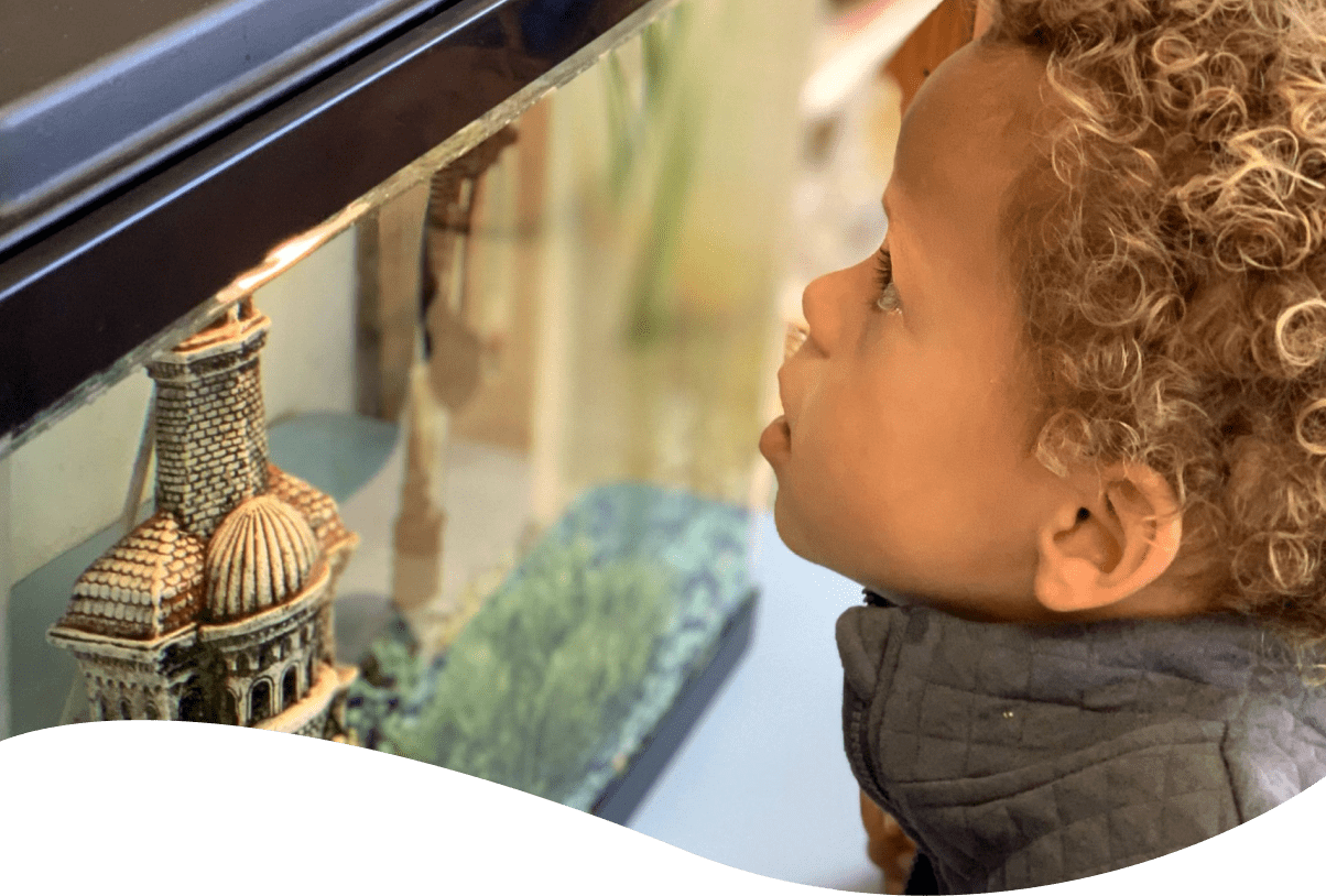 A young boy looking at a model of the eiffel tower.