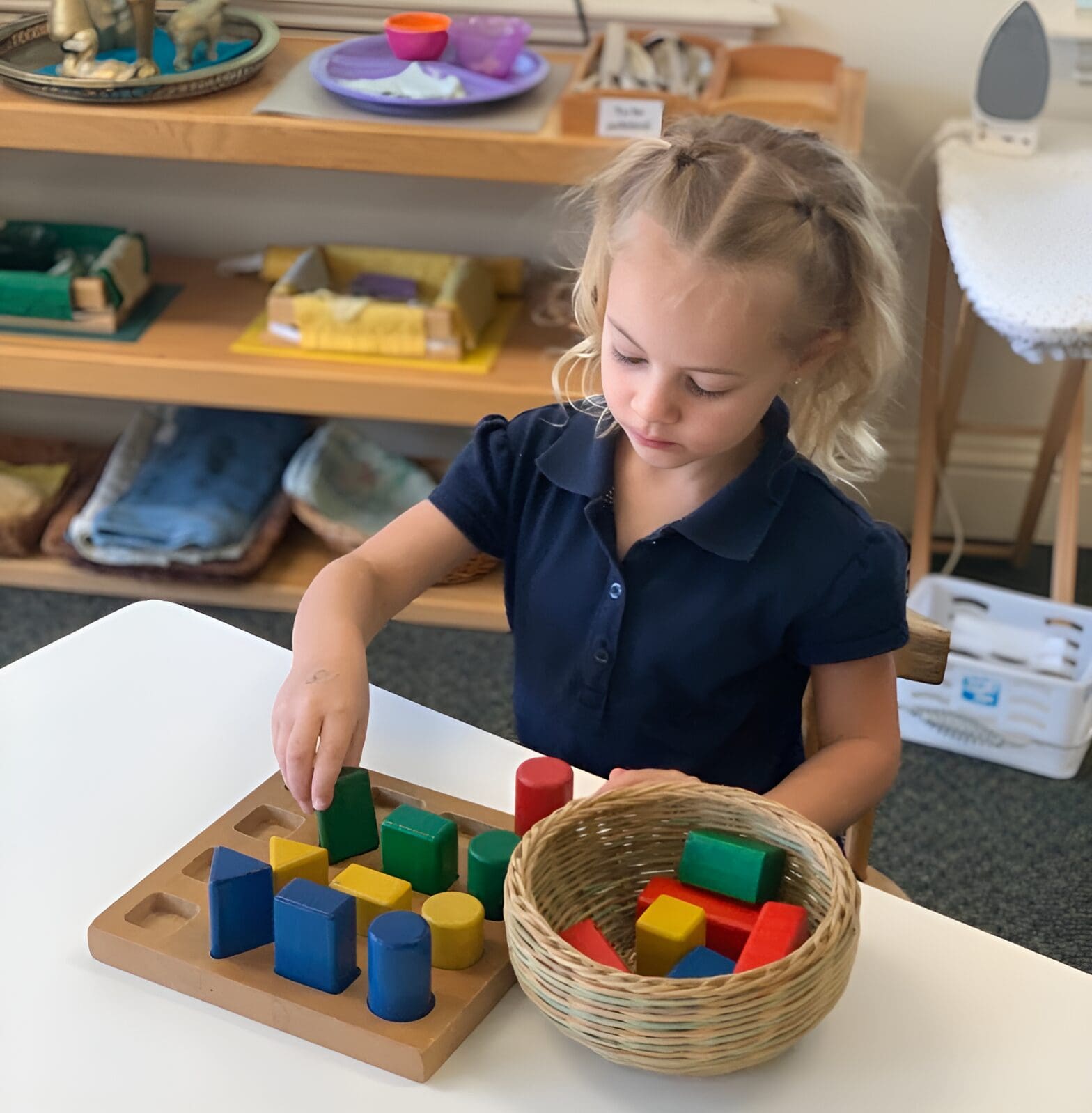 A little girl playing with blocks on the table